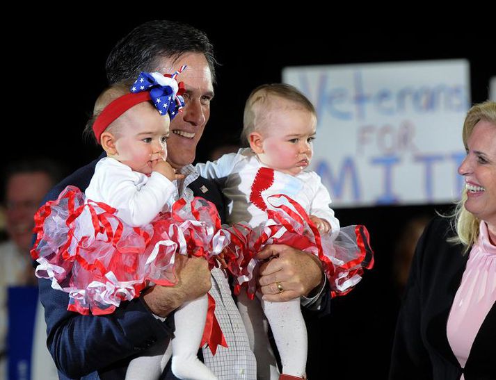 Í frambjóðendastellingum Mitt Romney á framboðsfundi með börnin smá í fanginu.