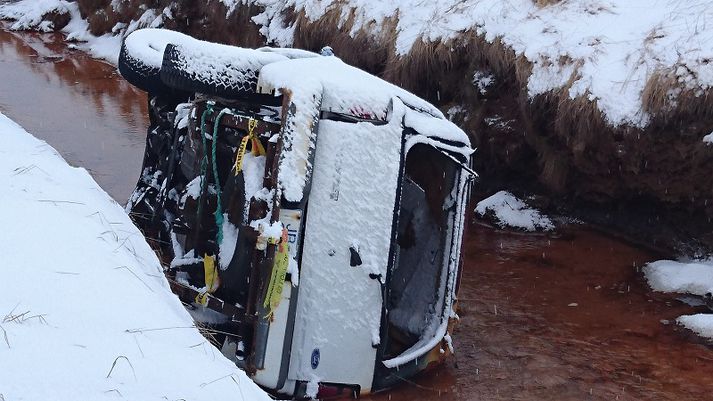 Bílinn valt ofan í skurðinn á gamlárskvöld 2015.