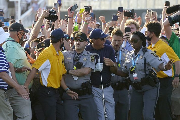 Phil Mickelson reynir að troða sér í gegnum áhorfendahópinn á mótinu um helgina.