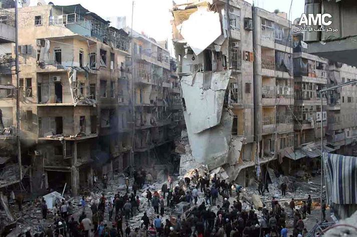 Íbúar Aleppo virða fyrir sér rústir bygginga sem urðu fyrir sprengitunna.