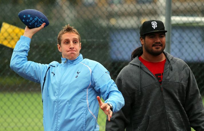 Michael Dawson gerir tilraun til að kasta bandarískum fótbolta. Mike Lupati lætur sér fátt um finnast