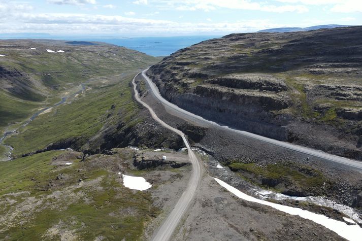 Nýi vegurinn úr Vatnsfirði og upp á Dynjandisheiði liggur um Pennusneiðing. Gamli vegurinn hlykkjast í hlíðinni fyrir neðan. Gamla brúin yfir Þverdalsá sést fyrir miðri mynd. Fjær sést út á Breiðafjörð.