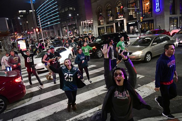 Stuðningsfólk Philadelphia Eagles hleypur fagnandi um göturnar í gær.