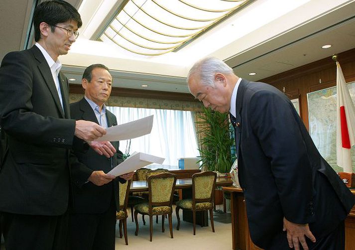 KYUMA sést hér taka við mótmælabréfi frá Tomihisa Taue, borgarstjóra Nagasakí, vegna ummæla sinna.