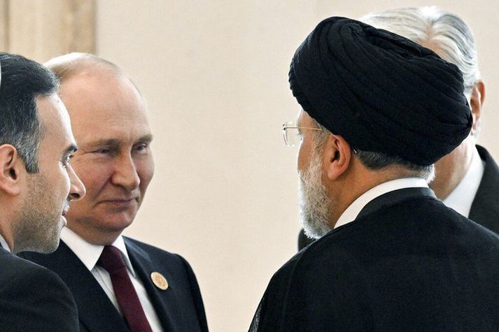 Vladimir Putin forseti Rússlands ræðir við Ebrahim Raisi forseta Írans sem snýr baki í myndavélina í Teheran í dag.