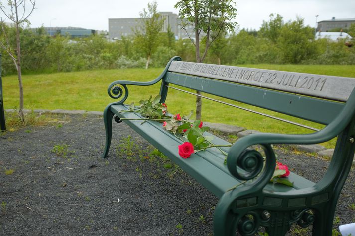 Nokkrir lögðu rauðar rósir á bekk í minningarlundinum í Vatnsmýrinni í dag.