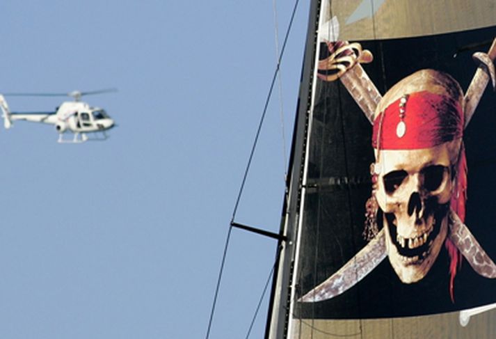 Þyrla flýgur yfir skip sem sigldi undir fána kvikmyndarinnar Pirates of the Caribbean í siglingakeppni.