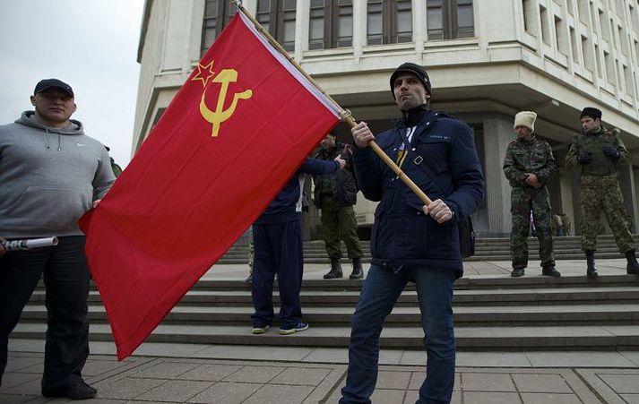 Íbúi í borginni Simferopol á Krímskaga heldur á sovéska fánanum fyrir utan þinghús borgarinnar.