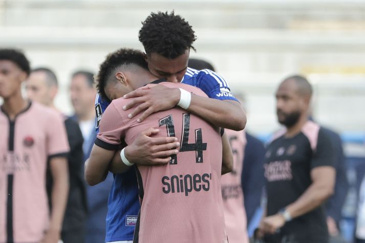 Guela Doue hjá Strasbourg (blá treyja) faðmar hér yngri bróður sinn, Desire Doue hjá PSG, eftir að þeir mættust í frönsku deildinni um helgina.