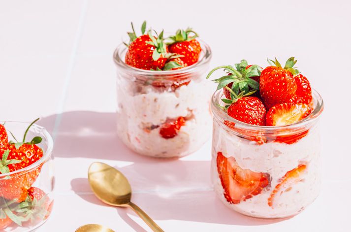 Refreshing Overnight Oats with Yogurt and Strawberries in Glass Jars on Pink Tile Table