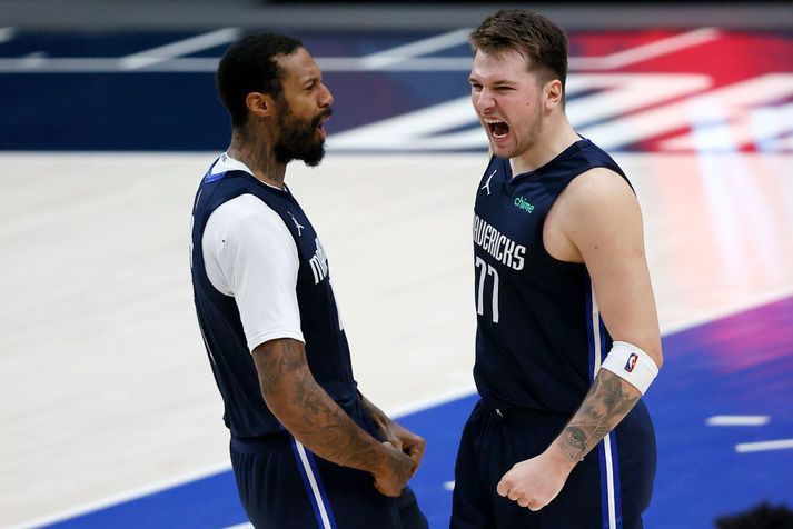 Luka Doncic fagnar sigurkörfunni með James Johnson í Dallas í nótt.