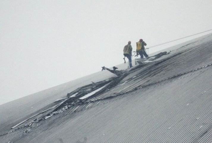 Verkamenn skoða gatið sem íranskur dróni á vegum Rússa skildi eftir sig í steinhvelfingunni utan um Tsjernobyl-kjarnorkuverið.