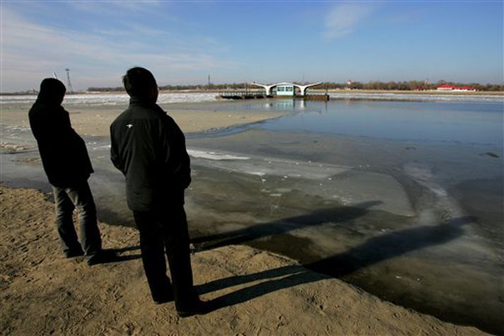Íbúar í Harbin standa við ána Songhua sem er nú menguð á 80 kílómetra kafla.