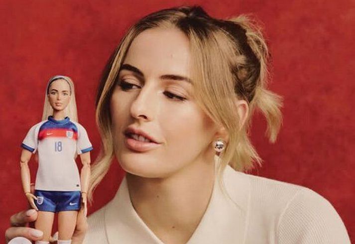 Chloe Kelly með Barbie-dúkkuna af sér sem er í enska landsliðsbúningnum.