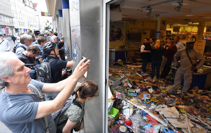 Fólk tekur myndir af skemmdum í Schanzenviertel stórmarkaðnum. Mótmælendur unnu miklar skemmdir þegar fundur G20 ríkjanna fór fram.