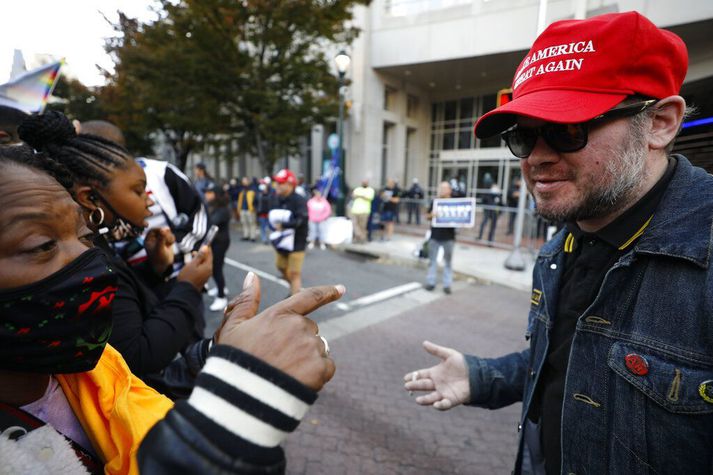 Liðsmaður hægriöfgasamtakanna „Stoltu strákanna“ með derhúfu til stuðnings Trump forseta rökræðir við mótmælanda í Fíladelfíu eftir kosningarnar í síðustu viku. Talið er að liðsmenn hreyfingarinnar ætli að fjölmenn til höfuðborgarinnar til að styðja forsetann.