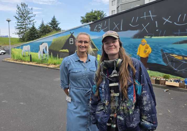 Bryndís Rut Logadóttir, Þjónustustjóri Hrafnistu á Sléttuvegi (t.v.) og Karen Ýr Sigurbjörnsdóttir, vegglistakona og sjálflærður málari með verkið á bak við sig.