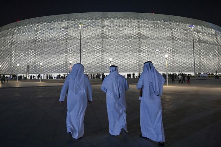 Þrir menn fyrir utan Al Thumama leikvanginn í Doha þar sem verður spilað á HM í næsta mánuði.