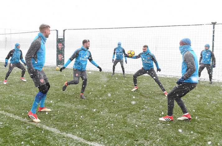 Arsenal menn á æfingu í snjónum en þeir fá topplið Manchester City í heimsókn í kvöld.