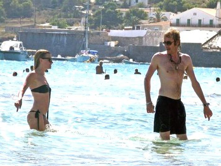 Ónefnd kona og leikarinn Rhys Ifans busla saman í sjónum.