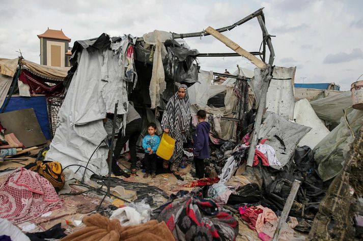 Palestínsk fjölskylda á vergangi leitar í tjaldi þeirra eftir árásir vestur af Rafah í dag.