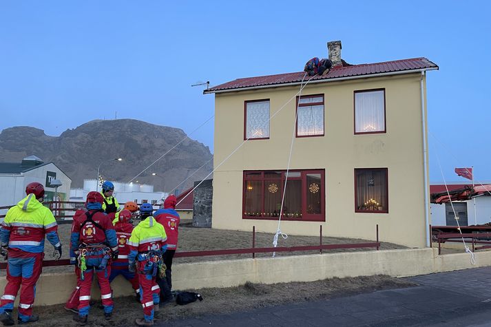 Björgunarsveitarfólk kemur hér böndum á húsþak í Vestmannaeyjum.