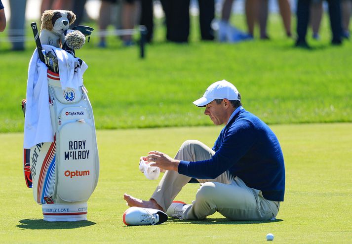 McIlroy settist niður á þriðju braut og var greinilega að finna fyrir óþægindum á hægri fæti.