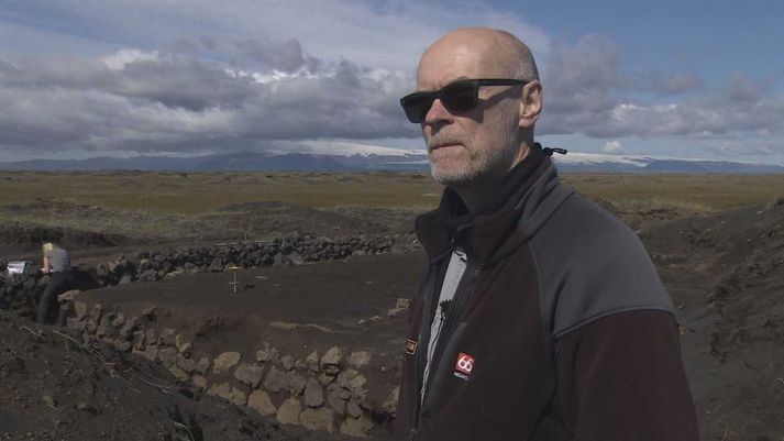 Bjarni F. Einarsson fornleifafræðingur við bæjarrústirnar á Mýrdalssandi. Hér afhjúpast eyðingarmáttur Kötlu, sem sést í baksýn.