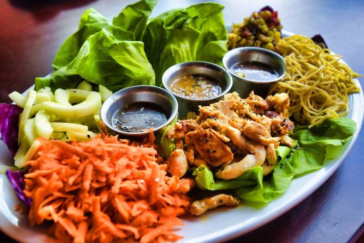Rétturinn samanstendur af satay kjúklingi, hnetusósu, kókos-karrínúðlum og fersku grænmeti, allt borið fram á smjörsalatblöðum sem gera það einfalt að búa til eigin salatvefjur.