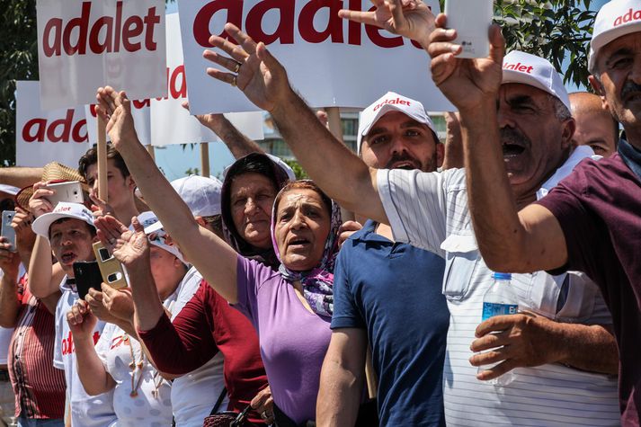 Mótmælendurnir halda meðal annars á skiltum þar sem stendur á adalet en það þýðir réttlæti.