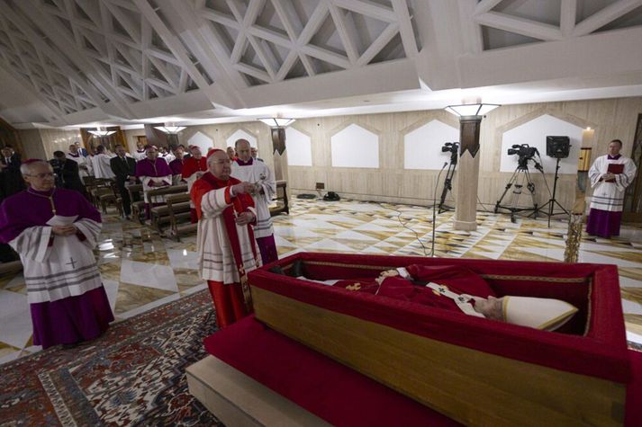 Líkvaka páfa hefst í kirkjunni í Santa Marta en hann verður svo fluttur í Péturskirkju á miðvikudag. Hér ámyndinni sést kardinálinn  Kevin Joseph Farrell við lík Frans páfa. Hann staðfestir hér andlát hans. Myndinni var dreift af Vatíkaninu. 