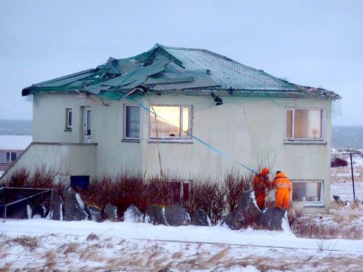 Nágrannar hússins Víkur á Rafnkelsstaðavegi hafa í tvö ára fylgst með fiskineti halda lausum þakplötum í skefjum þegar vindar blása um Garðinn. Farg í fiskikari er notað til að binda stög úr netinu.