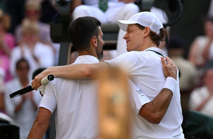 Jannik Sinner með Novak Djokovic eftir sigur sinn í undanúrslitaleik þeirra í kvöld.