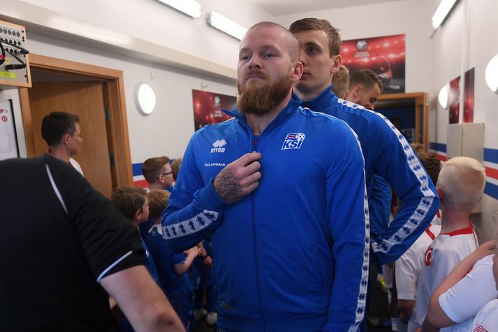 Aron Einar Gunnarsson býr sig undir það að leiða íslenska landsliðið inn á völlinn.