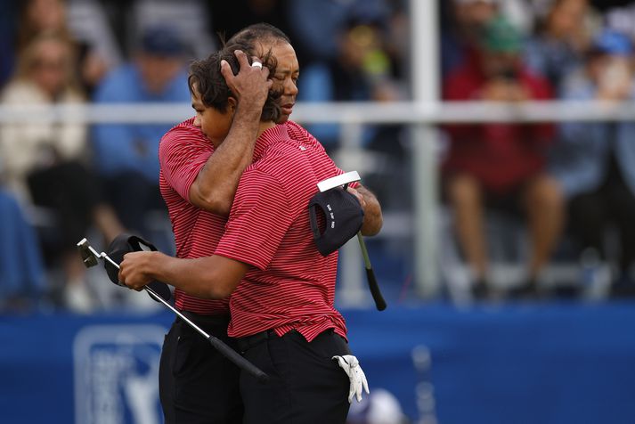 Tiger Woods faðmar hér son sinn Charlie Woods eftir að þeir spiluðu saman á feðgamótinu í desember