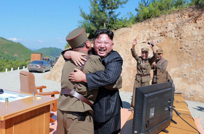 Kim Jong-un, einræðisherra Norður-Kóreu, sést hér fagna eldflaugatilraun vikunnar með faðmlagi. Hann er uppspretta óánægju Donalds Trump Bandaríkjaforseta sem vill að Kínverjar láti af viðskiptum við Kim.