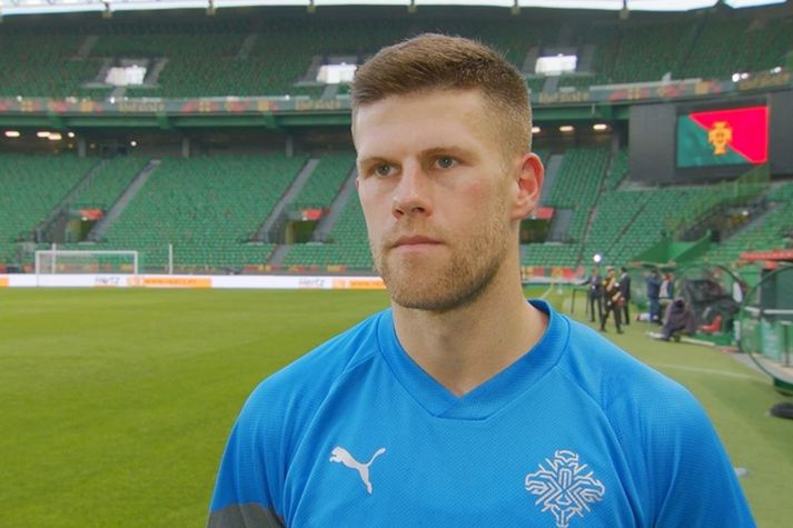 Jóhann Berg Guðmundsson leiðir íslenska landsliðið inn á José Alvalade leikvanginn í Lissabon í kvöld í leik gegn heimamönnum frá Portúgal.