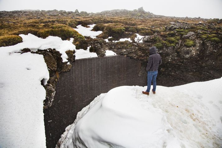 Mikið timburþil hefur verið sniðið vandlega að munna Raufarhólshellis.

