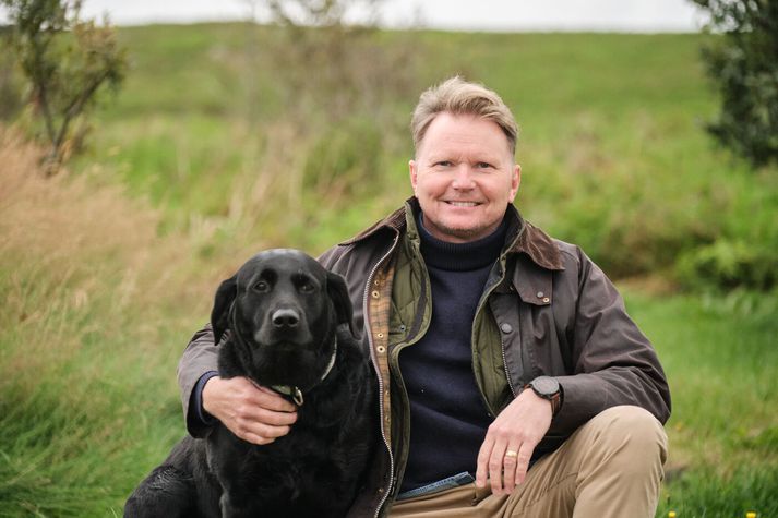 Guðni Aðalsteinsson, forstjóri Reita og hundurinn hans Astró. Guðni segir það henta fjölskyldunni vel hversu fljótur hann er út úr húsi og í vinnuna á morgnana. Því oft finnist þeim hann tala heldur mikið í morgunsárið.