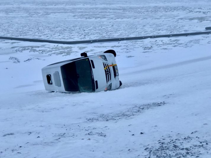 Önnur rútan valt á hliðina utan við veginn. Sautján ferðamenn voru í henni.