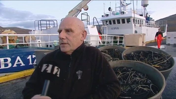 Guðjón Indriðason, útgerðarmaður á Tálknafirði. Fiskiskipið Kópur BA er fyrir aftan en það hefur nú verið selt til Suðurnesja.