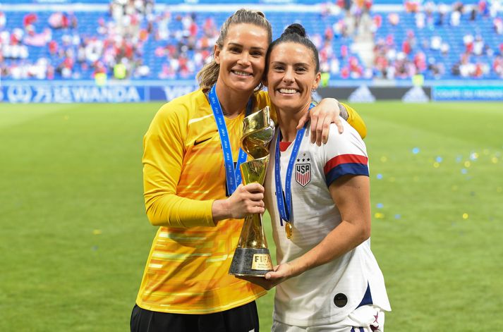 Ashlyn Harris og Ali Krieger saman með heimsbikarinn eftir að Bandaríkin vann árið 2019.