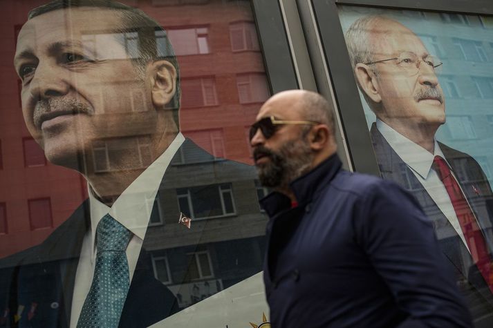 Maður gengur hjá myndum af Recep Tayyip Erdogan og Kemal Kilicdaroglu í Istanbúl.