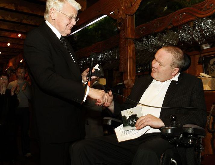 Ólafur Ragnar Grímsson, forseti Íslands, tekur við hljóðbókinni frá Guðjóni Sigurðssyni, formanni MND-félagsins.