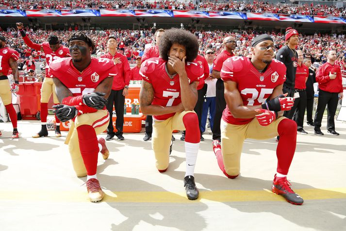 Colin Kaepernick (fyrir miðju) hefur ekki spilað í NFL síðan hann hóf friðsamleg mótmæli er þjóðsöngur Bandaríkjanna var sunginn fyrir leiki.