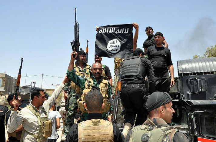 Íraskir hermenn halda á lofti herteknum fána ISIS um 60 kílómetra norður af Bagdad. Fréttablaðið/AP 
