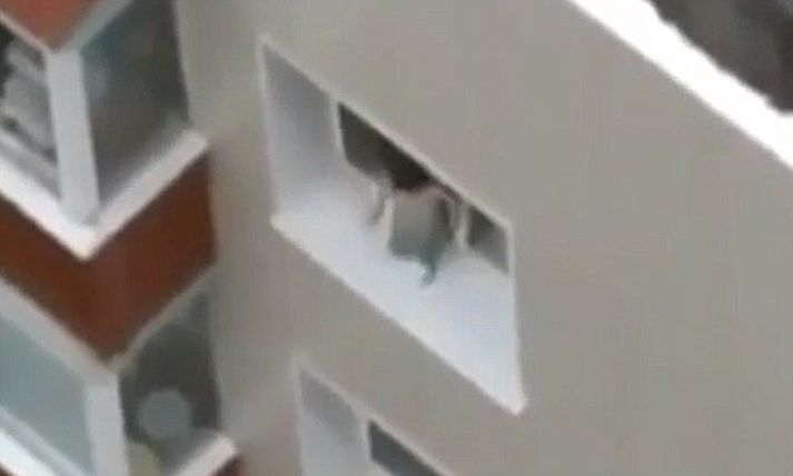 Enginn í íbúðinni virtist taka eftir því að barnið var eitt á vappi utan við gluggann.