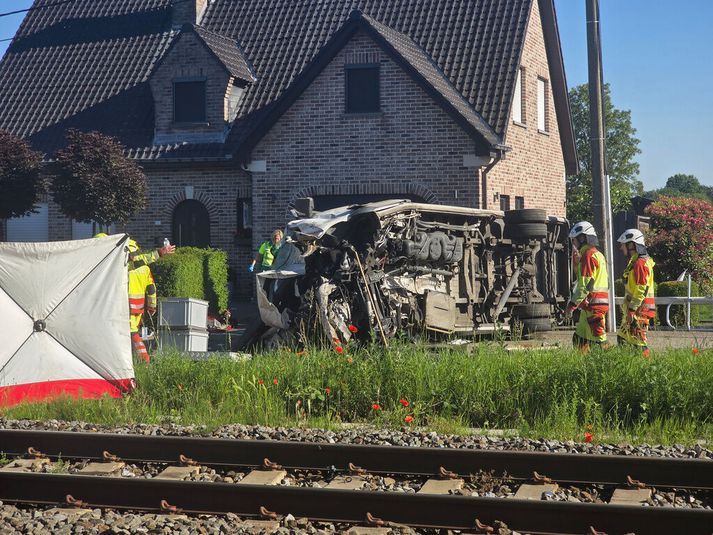 Smárútan liggur á hliðinni nærri lestarteinunum í Buggenhout í Flæmingjalandi í Belgíu. Tvö börn eru látin, tveir fullorðnir og fimm börn eru alvarlega slösuð eftir að rútan varð fyrir lest á mikilli ferð.