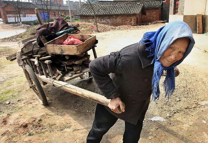 Gömul kona dregur vagn í borginni Jiujiang skammt frá Jangtse-fljótinu.