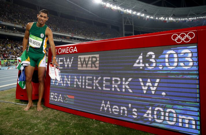 Wayde van Niekerk við hlið töflu sem sýnir nýtt heimsmet hans.